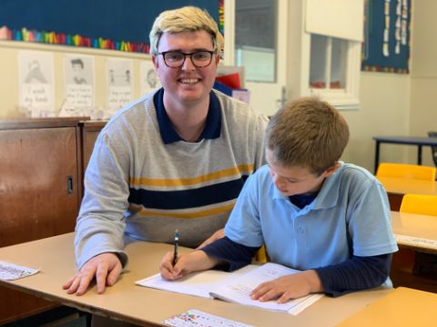 Ed Smith pictured helping one of his students with class work